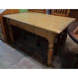 A 4' 6" waxed pine farmhouse kitchen table, set on turned legs