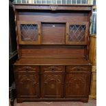 A 4' 6" modern oak effect two part dresser with leaded style doors to top, three drawers and