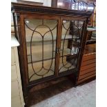 A 3' 7" Edwardian walnut display cabinet with three material lined shelves enclosed by a pair of