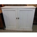 A 3' 5" painted wood two door cupboard, set on plinth base