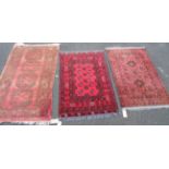 An old faded red Bokhara rug with four large guls, a 20th Century red Bokhara two ten small guls and