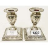 A pair of 4 1/2" silver candlesticks with embossed harebell garland and beaded decoration, set on