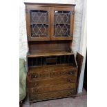 A 36" 20th Century polished oak bureau bookcase with leaded glazed top over part fitted interior and