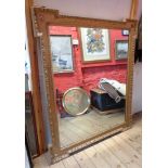 An antique gilt gesso framed wall mirror with stepped corners and applied rosettes - replacement