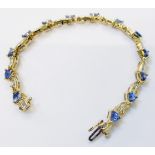 A cased 14ct. gold fancy link bracelet, set with triangular cut tanzanites interspersed with pave
