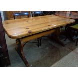 A 5' modern varnished pine thick sectional top dining table, set on shaped standard ends with pegged