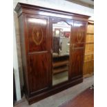 A 6' 5" Edwardian inlaid mahogany triple wardrobe with moulded cornice, linen slides, three