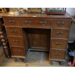 A 34" early 20th Century oak kneehole desk with rexine inset top, three frieze drawers, central