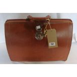 A vintage brown leather briefcase with keys