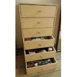 A laminated wood six drawer chest containing a selection of clock making tools and accessories,