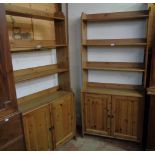 A pair of 36 1/2" stained pine cabinets with triple open bookshelves over