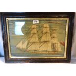 An antique woolwork of a full-rigged ship in an ebonised frame