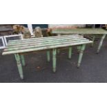 A pair of antique painted pine potting benches with slatted tops, set on turned and faceted legs