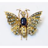 A 1 1/4" wingspan Victorian high carat yellow metal butterfly pattern brooch, set with oval ruby