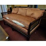 A 1930's polished walnut framed bergere three piece suite with copper coloured upholstery and
