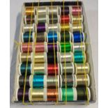 A box containing a quantity of metallic embroidery threads