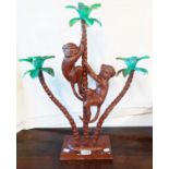 A three branch candlestick in the form of monkeys climbing a palm tree