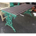 A garden table with slatted top set on cast iron ends - length 5' 7"