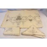 A large early 20th Century cut threadwork and embroidery linen tablecloth with matching napkins