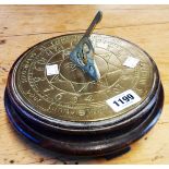 A reproduction brass sundial on oriental wood stand