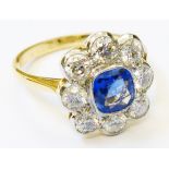 A marked 18ct. yellow metal ring, set with central 1.25ct. sapphire within an eight stone diamond