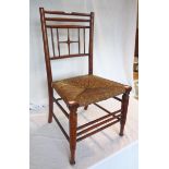 An early 20th Century stained wood child's Sussex style chair with woven rush seat panel and slender