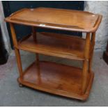 A vintage Ercol pattern three tier tea trolley with later varnished finish