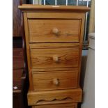 A pair of 15 1/2" waxed pine three drawer bedside chests, set on bracket bases