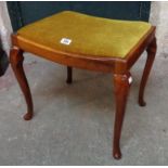 An Edwardian varnished mahogany dressing stool with upholstered drop-in seat, set on slender