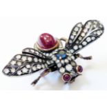 A 2" wingspan insect pattern brooch, set with sapphire to thorax, ruby eyes, large ruby cabochon