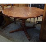 A 3' 11" diameter stained wood pedestal dining table, set on turned pillar and moulded legs