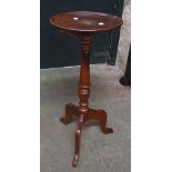 A reproduction wine table with copper and brass inlaid top, set on turned pillar and tripod base