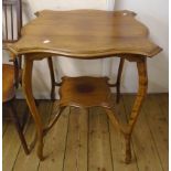 A 24" Edwardian stained wood two tier occasional table with shaped surfaces set on slender