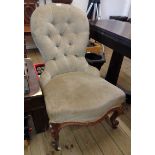 A Victorian spoon back nursing chair with button back velour upholstery, set on stylised cabriole