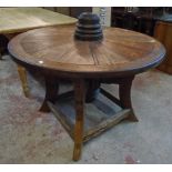 A 3' 6" diameter rustic dining table formed from an iron ringed cart wheel and two fused wheel hubs,