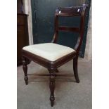 A pair of Regency mahogany framed dining chairs with upholstered drop-in seats, set on turned