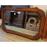 An early 20th Century stained oak framed bevelled wall mirror with moulded decoration - sold with