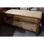 A 3' 6" 20th Century stained pine two tier coffee table, set on turned supports