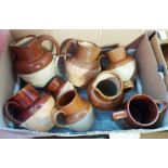 Two boxes containing Royal Doulton and other brown glazed jugs, etc.