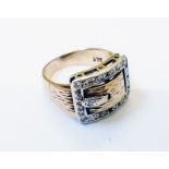 A marked 9ct. yellow and white metal buckle pattern ring, with diamond set border