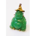 A marked 14k yellow metal mounted carved jade Buddha pattern pendant