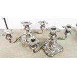 A pair of silver plated squat three branch candelabra with embossed grapevine decoration