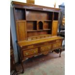 A 5' 5 1/2" antique polished oak and mahogany strung two part dresser with shelves, central arched