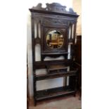 A 3' 9" late Victorian carved and stained oak hallstand with shaped pediment, circular bevelled
