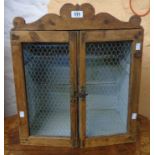 An 18" antique waxed pine wall hanging cabinet with painted interior and wire mesh to doors - as a