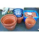 Six large terracotta plant pots and another - sold with a quantity of pot stands