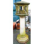 A concrete octagonal dove cote pattern bird table, set on a faceted tapered pillar base