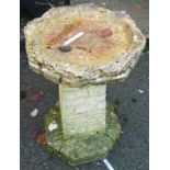 A 24" concrete bird bath, set on a brick effect pedestal base