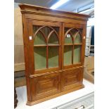 A 27" waxed pine wall hanging corner cabinet with Gothic style glazed panel doors and pair of