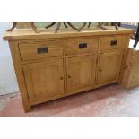 A 4' 10" modern polished golden oak sideboard with three drawers and three panelled cupboard doors